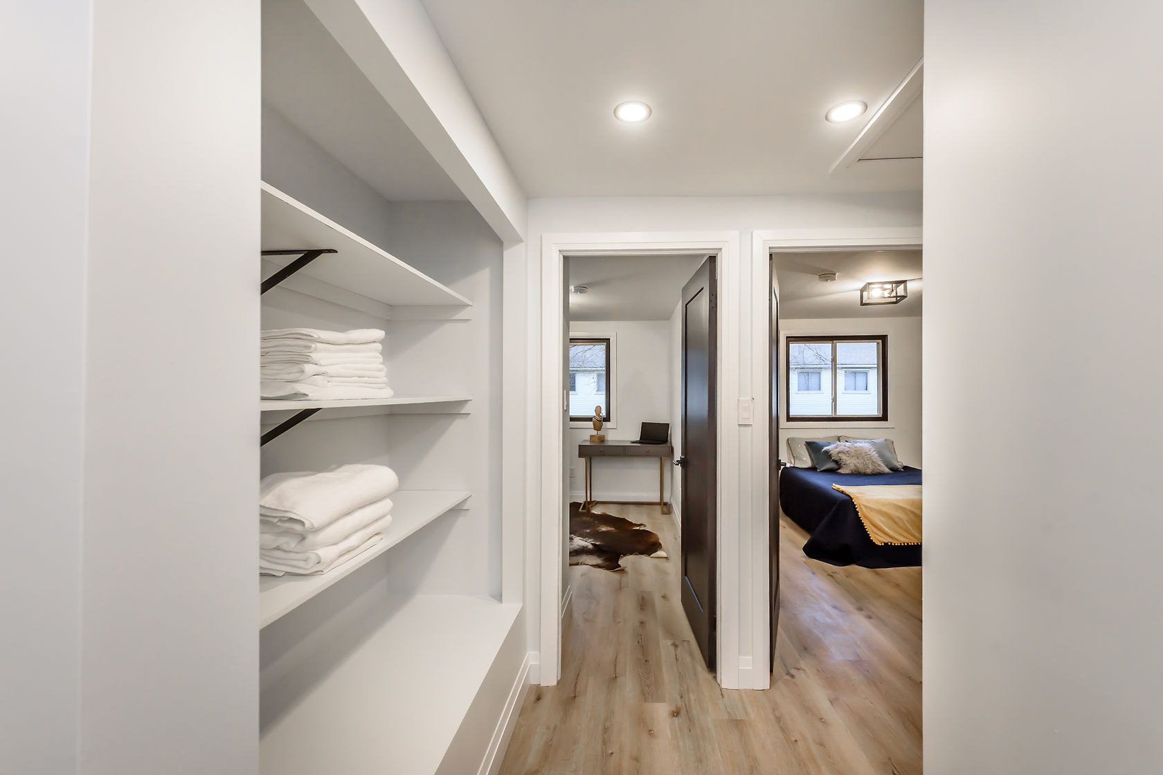 Professional wide-angle finished hallway with built-in linen storage, warm lighting, and clean sight lines to bedroom — Gateshead, Hamilton | MTC Renovations